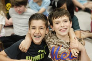 Two students smiling with arms around each other
