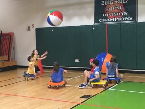 Students playing with inflatable beach balls inside the gymnasium