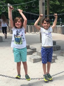 Two students playing with playground equipment