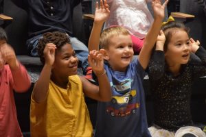 EC Students excitedly raising their arms