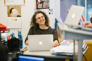 Teacher smiling at colleague out of frame