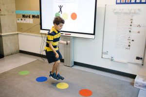 Student jumps onto a dot mat on the floor