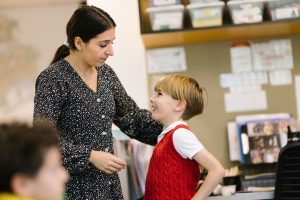 Student smiles up at teacher