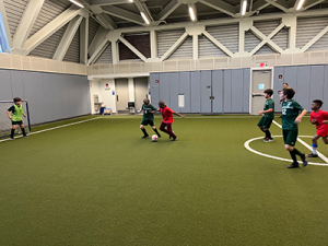 Gaynor soccer team playing a match in the fieldhouse