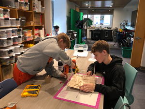 Students building their devices from popsicle sticks