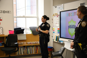 Officer Murphy holds up metal handcuffs to show the class