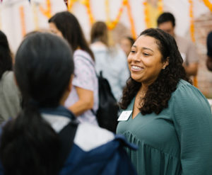 A smiling Gaynor employee welcomes parents to a school event.