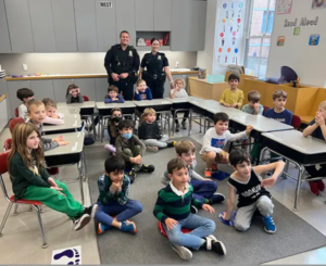 Students pose as a group with two police officers in the back