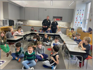 Students pose as a group with two police officers in the back