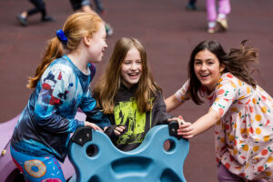 Three students playing on the playdeck.