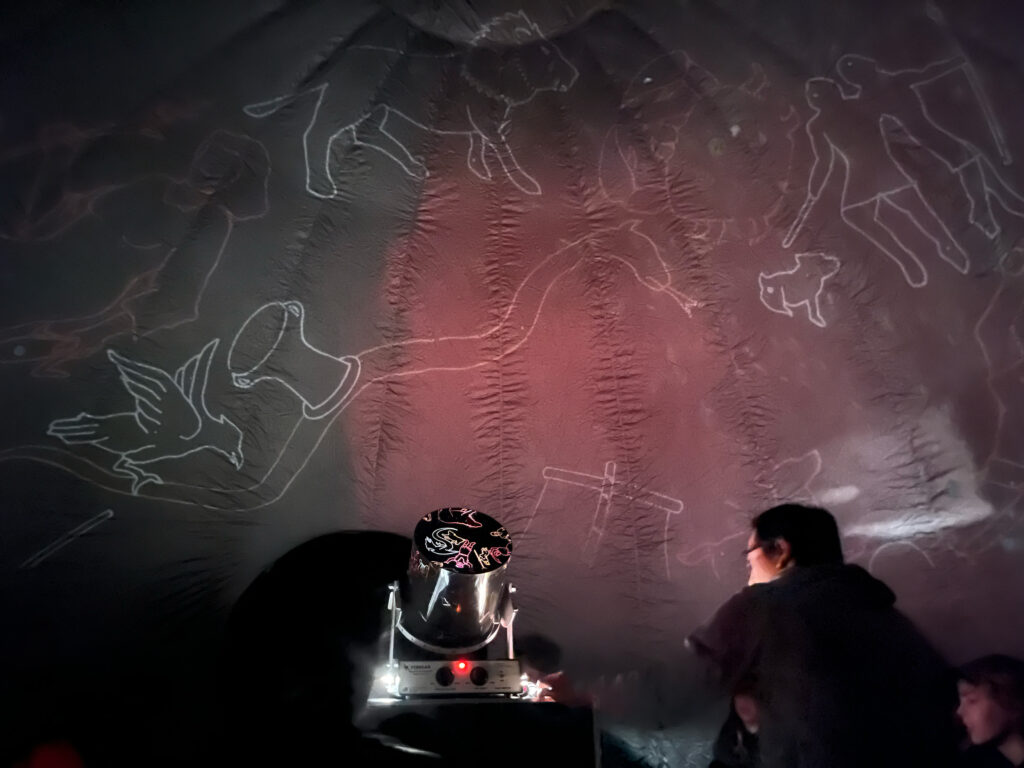 Science Specialist Andrew Prasarn readies the StarLab projector with a cylinder of constellations according to Greek mythology. The constellations are projected onto the inside of the StarLab's gray dome.