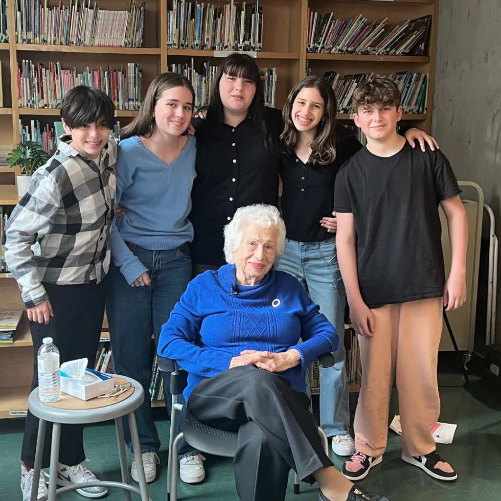 Students pose with the Holocaust survivor with whom they worked on Names, Not Numbers