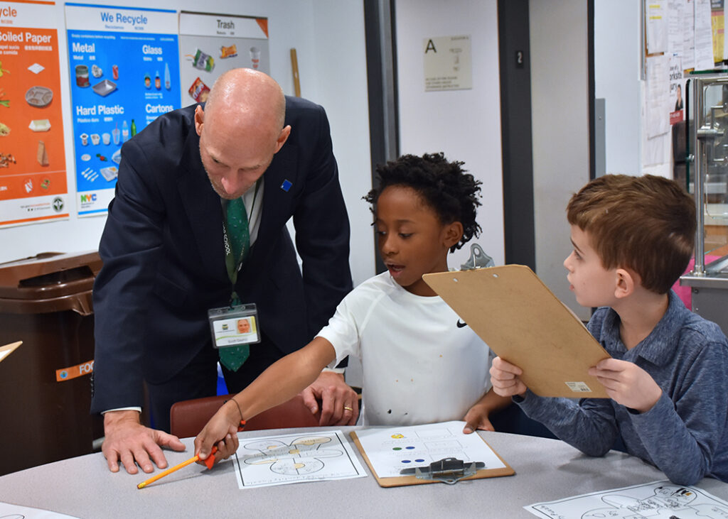 Head of School Scott Gaynor with two students at the Red Cluster identity fair