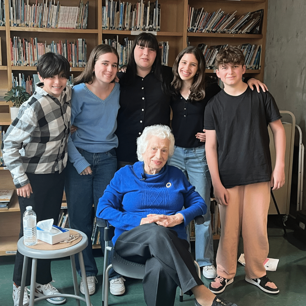 Students pose with the Holocaust survivor with whom they worked on Names, Not Numbers