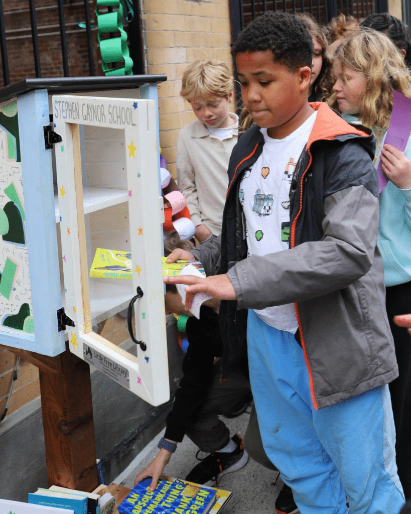 Students stocking the Little Free Library with the first selection of books.